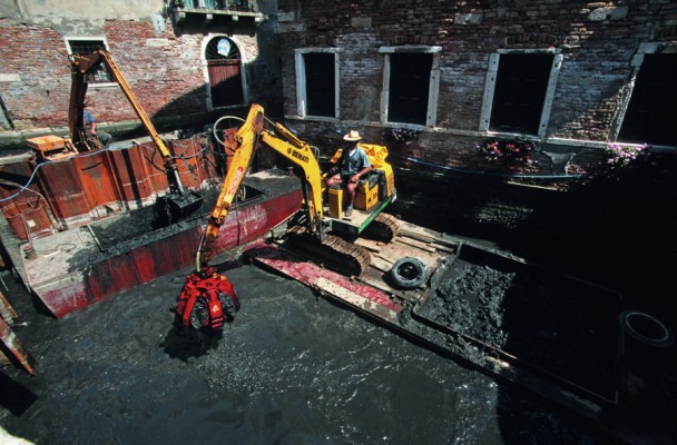 Rio dei Miracoli, June 1998.  The sludge is removed with hydraulic shovels and stored in bins, which are then loaded onto barges and taken to the dumping areas. 